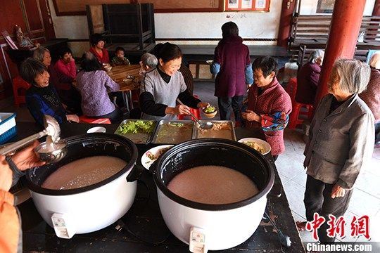 图为困难老人排队领粥。 王东明 摄