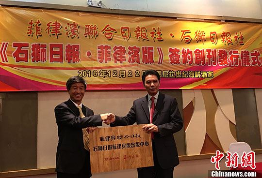 菲律宾联合日报总编辑董拔萃（右）与石狮日报总编辑茅罗平（左）移交牌匾，双方合作出版发行《石狮日报·菲律宾版》。中新社记者 张明 摄