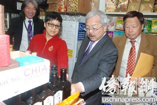 杂货店东主(红色毛衣者)向李孟贤介绍店内售卖的有机食品。(吴卓明 摄)